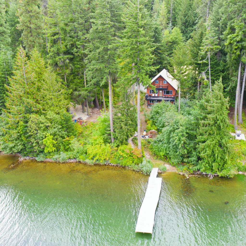 Cabane en bois rouge au bord d’un lac – logement insolite nature